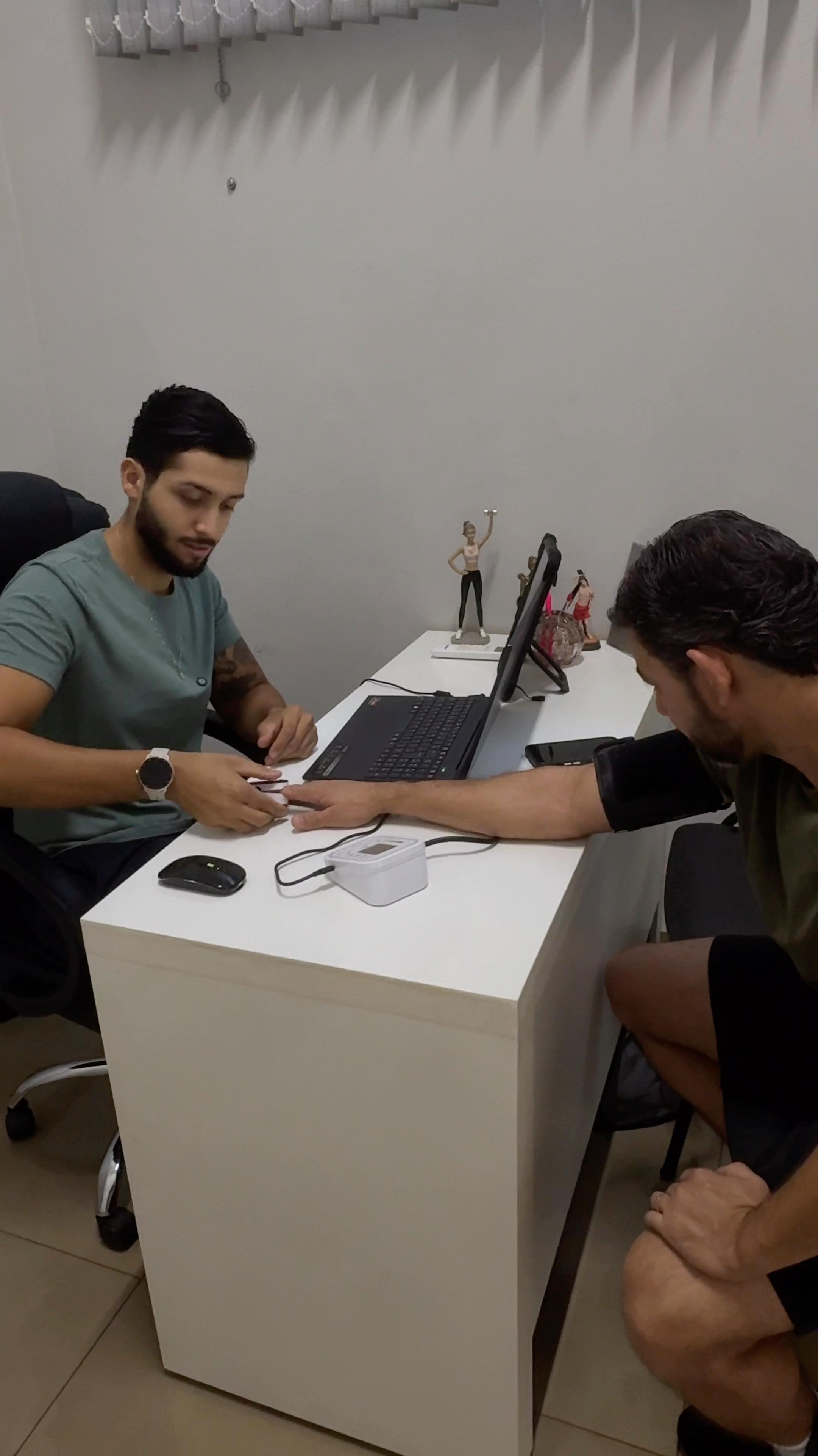 Renan realizando aferição de pressão e oximetria de um aluno